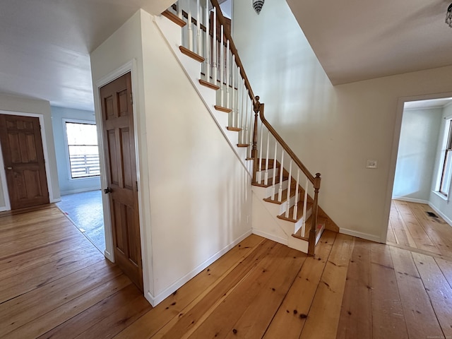 stairway featuring hardwood / wood-style flooring and baseboards