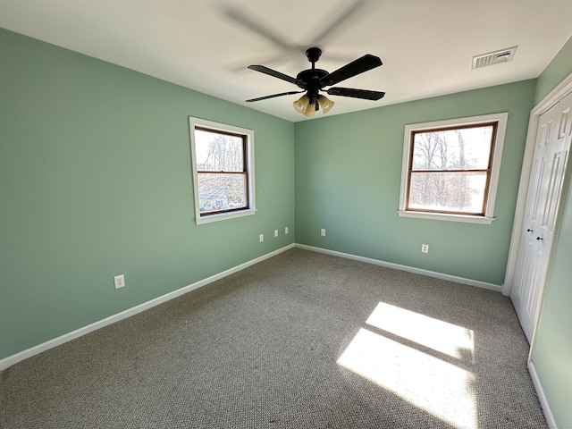 unfurnished bedroom featuring visible vents, baseboards, and multiple windows