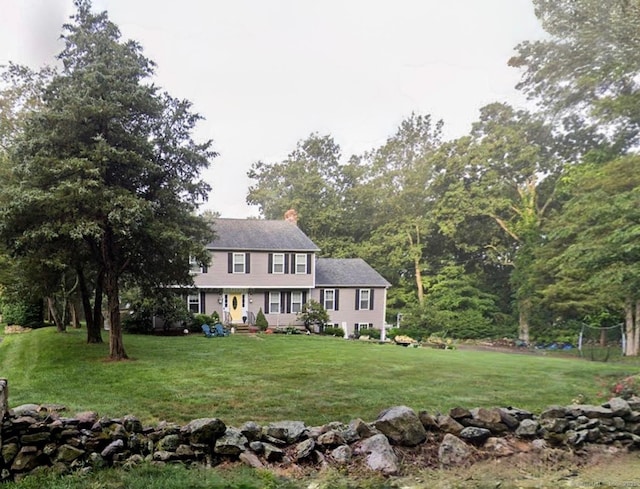 view of front of house with a chimney and a front lawn