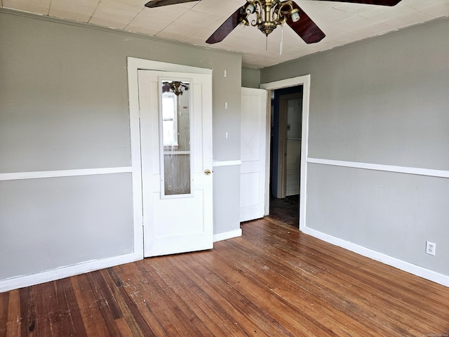 empty room with baseboards, wood-type flooring, and a ceiling fan