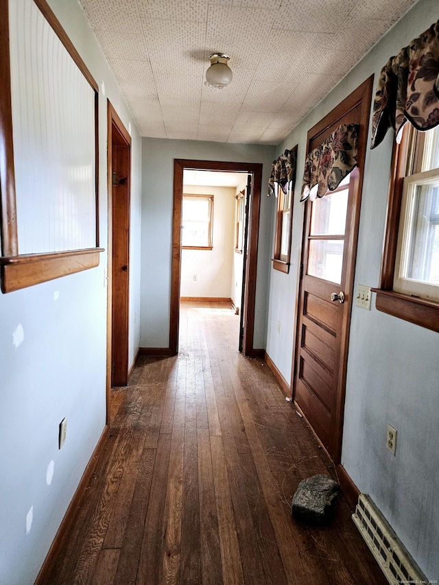 hallway featuring hardwood / wood-style floors, visible vents, and baseboards