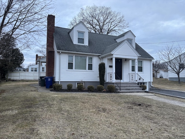 cape cod home with roof with shingles, fence, a chimney, and a front lawn