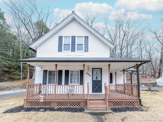 view of front facade featuring roof with shingles and covered porch