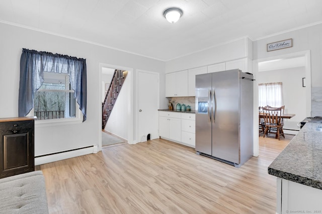 kitchen with light wood-style flooring, stainless steel fridge with ice dispenser, white cabinets, and a baseboard radiator