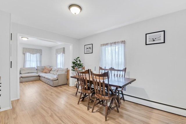 dining room with a baseboard radiator and light wood-style floors