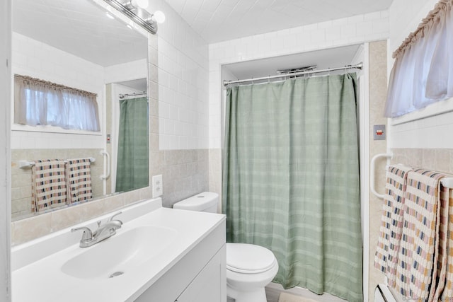 full bath featuring toilet, vanity, baseboard heating, a shower with curtain, and tile walls