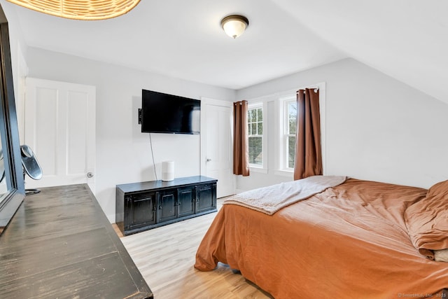 bedroom featuring lofted ceiling and light wood-style flooring