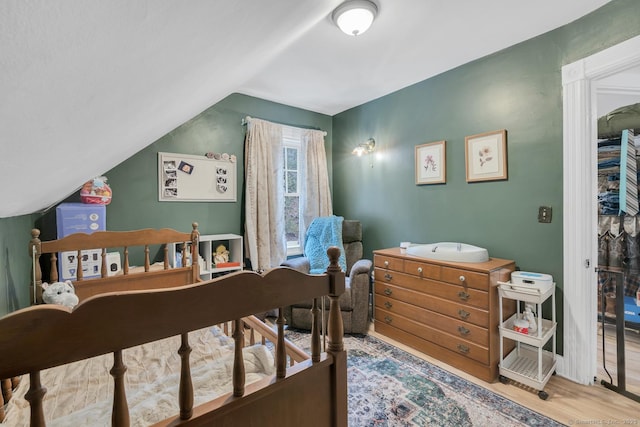 bedroom with lofted ceiling and wood finished floors