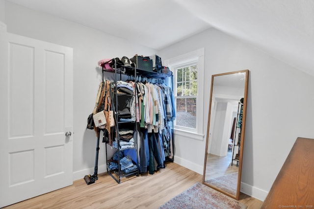 walk in closet with lofted ceiling and wood finished floors