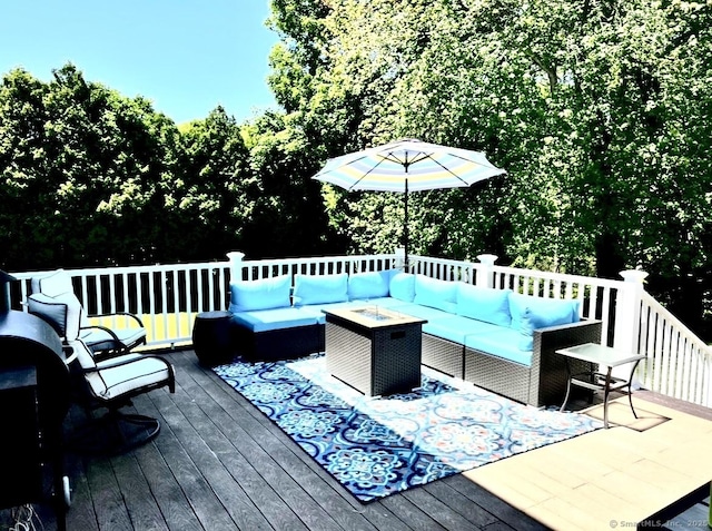 deck with an outdoor living space with a fire pit