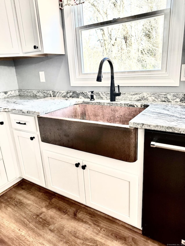 kitchen featuring white cabinets, dishwasher, dark wood-type flooring, and a sink