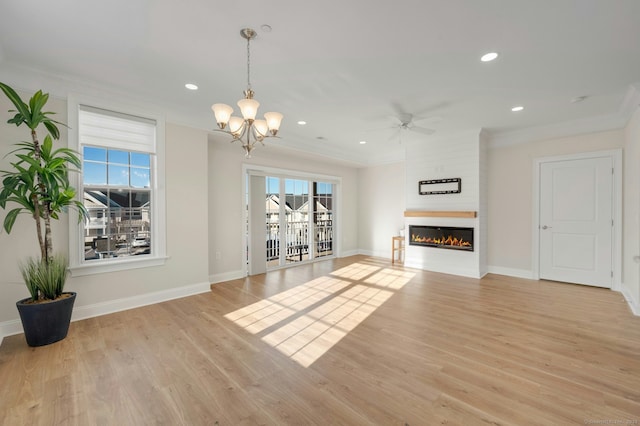 unfurnished living room featuring a large fireplace, light wood finished floors, baseboards, and crown molding