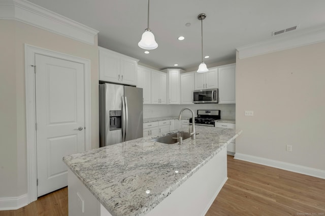 kitchen featuring light wood finished floors, visible vents, appliances with stainless steel finishes, white cabinetry, and a sink