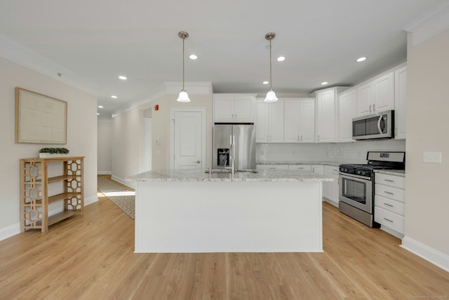 kitchen featuring stainless steel appliances, white cabinets, light wood-style flooring, and backsplash