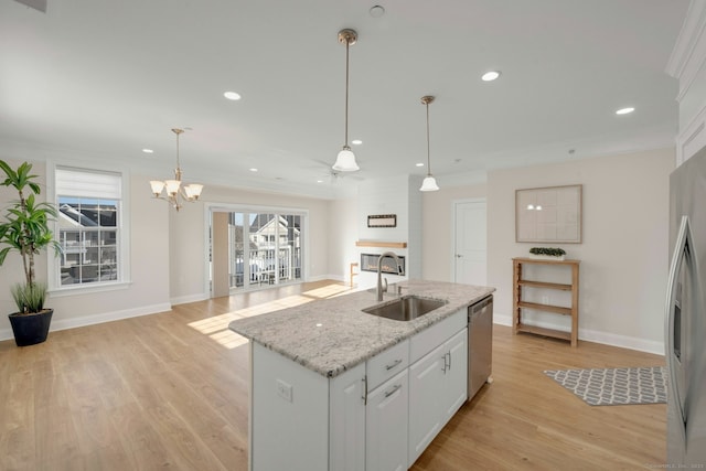 kitchen with a large fireplace, appliances with stainless steel finishes, a sink, and ornamental molding