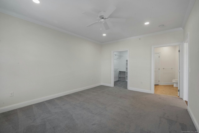 unfurnished bedroom featuring carpet, crown molding, recessed lighting, a spacious closet, and baseboards