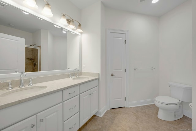 bathroom with toilet, visible vents, a tile shower, and a sink