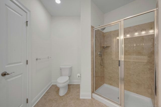 full bath with toilet, a stall shower, baseboards, and tile patterned floors