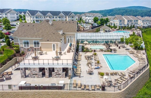 pool with a residential view, a patio, stairway, and fence