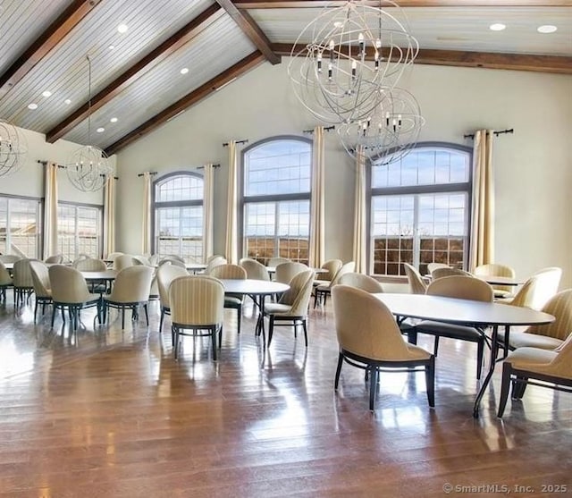 dining area featuring a chandelier, beam ceiling, and wood finished floors