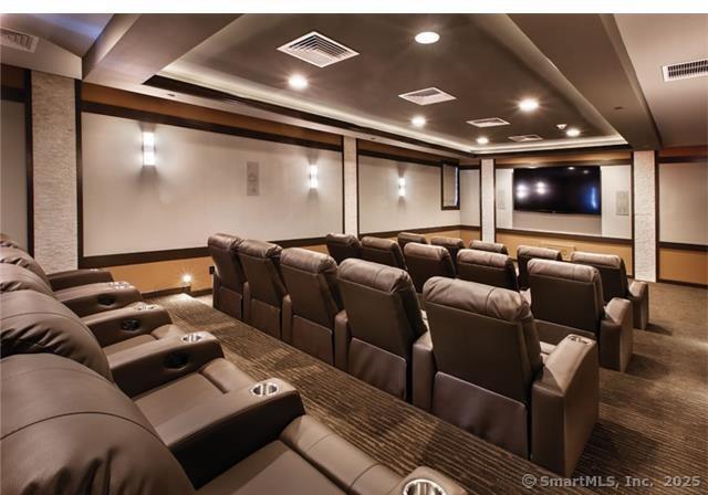 home theater with a tray ceiling, visible vents, carpet, and recessed lighting