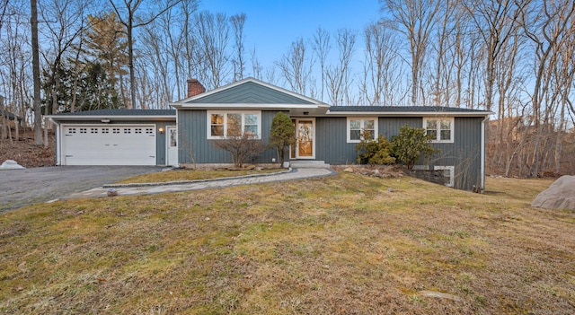 view of front of property with a front lawn, an attached garage, driveway, and a chimney