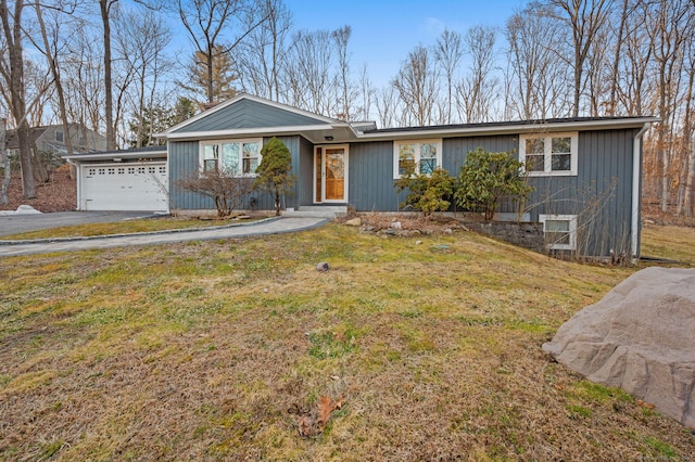 view of front of house with aphalt driveway, a garage, and a front lawn