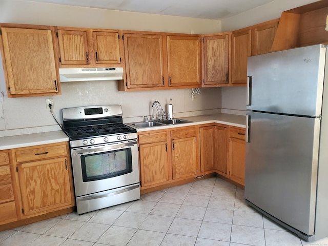 kitchen featuring light tile patterned floors, under cabinet range hood, stainless steel appliances, a sink, and light countertops