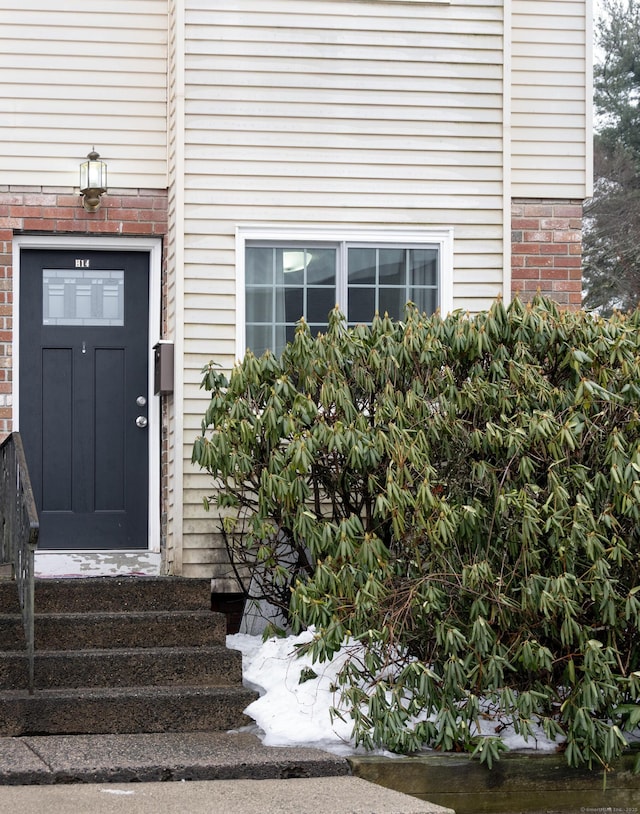 property entrance featuring brick siding