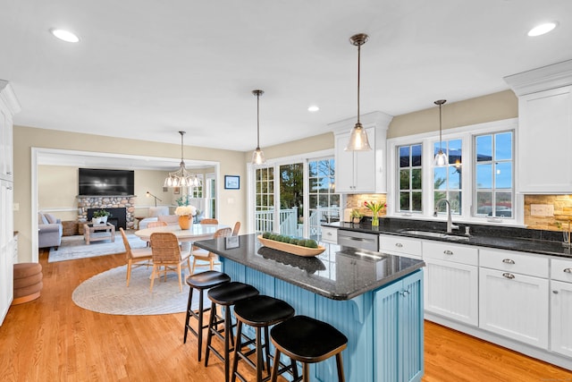 kitchen featuring light wood-style floors, white cabinetry, a sink, and decorative backsplash