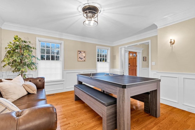 rec room featuring wainscoting, light wood-type flooring, and a healthy amount of sunlight