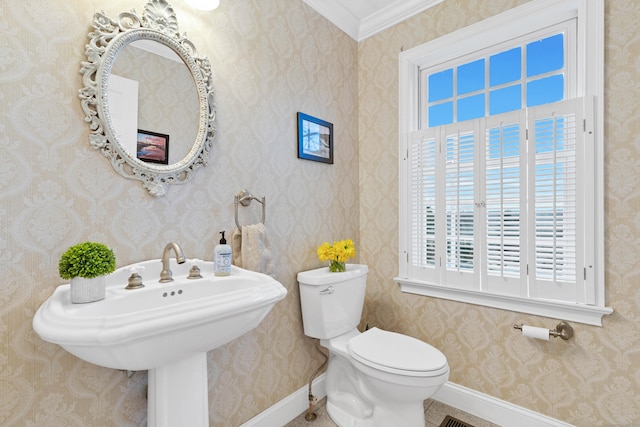 half bathroom with baseboards, a sink, and toilet