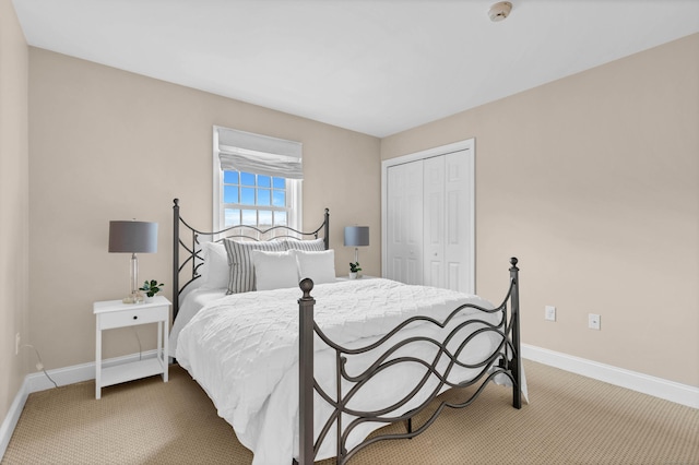 carpeted bedroom featuring a closet and baseboards