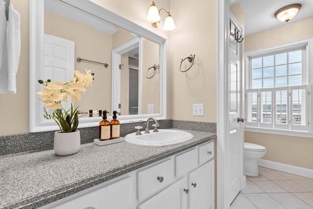 bathroom with baseboards, vanity, toilet, and tile patterned floors