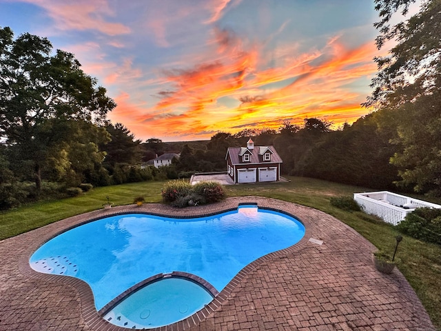 view of pool with an outbuilding, a pool with connected hot tub, a patio area, and a lawn