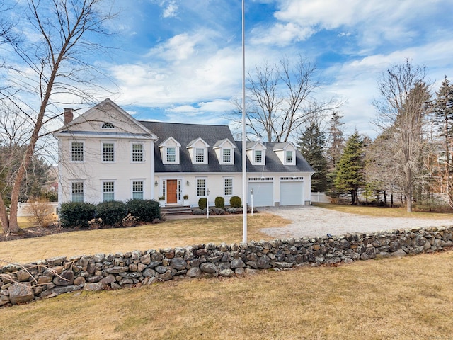 view of front facade featuring a garage, a front lawn, and gravel driveway