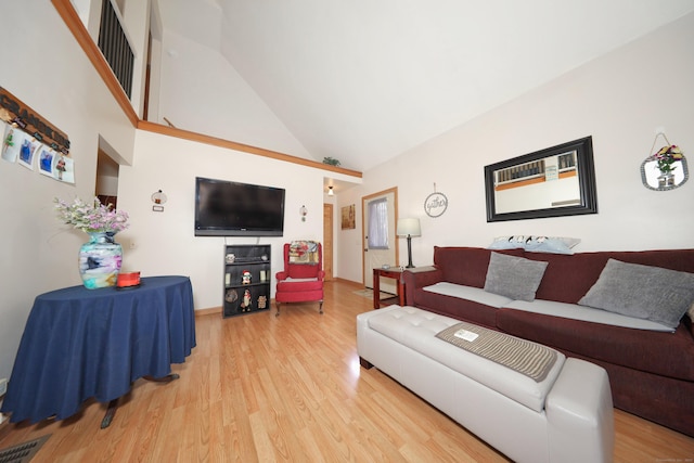 living room featuring visible vents, high vaulted ceiling, and light wood-style floors