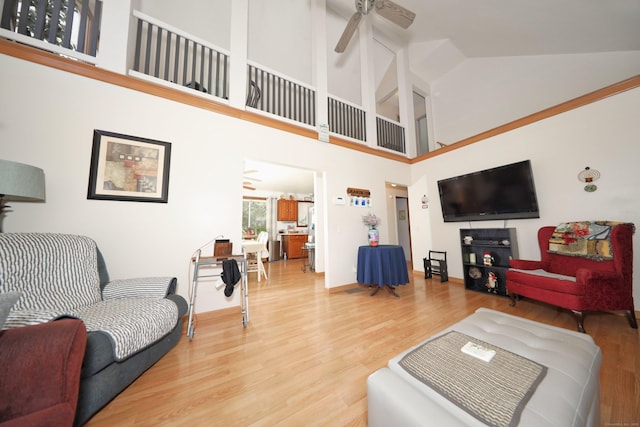 living area featuring lofted ceiling, ceiling fan, and wood finished floors