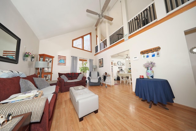 living room featuring high vaulted ceiling, wood finished floors, and a ceiling fan