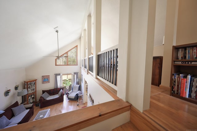 living area with ceiling fan, wood finished floors, and high vaulted ceiling