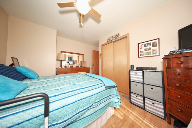 bedroom with a closet, light wood-style flooring, and a ceiling fan