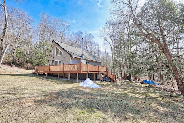 rear view of house featuring stairway, a yard, and a wooden deck