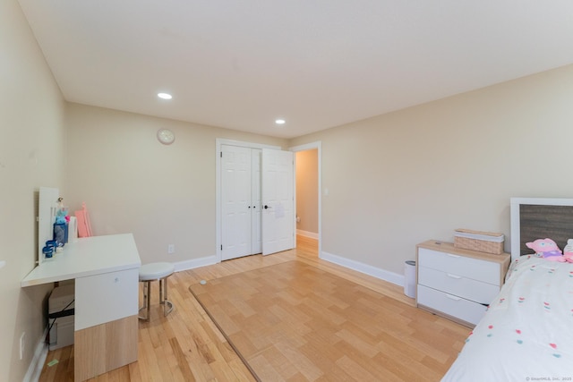 bedroom featuring a closet, recessed lighting, light wood-style flooring, and baseboards