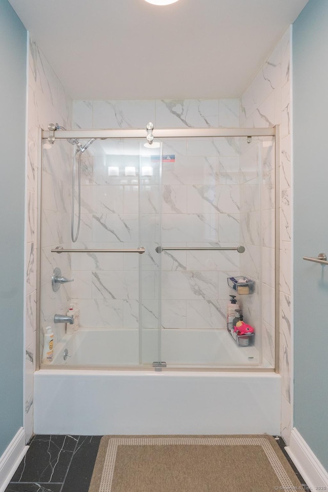 full bathroom with baseboards, shower / bath combination with glass door, and marble finish floor