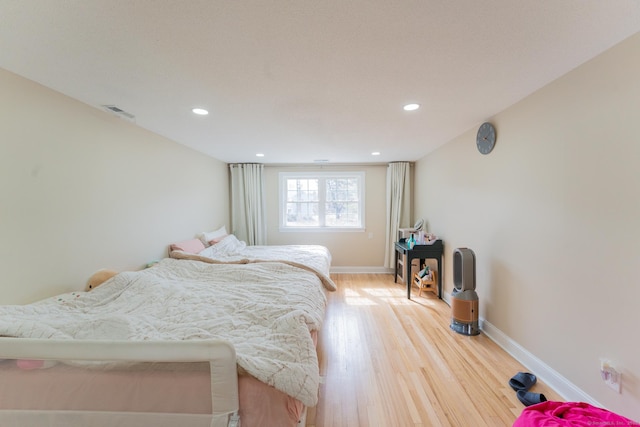 bedroom with light wood finished floors, visible vents, recessed lighting, and baseboards