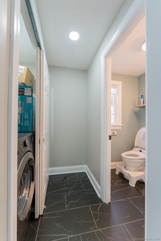 washroom with baseboards, washer / clothes dryer, marble finish floor, and laundry area