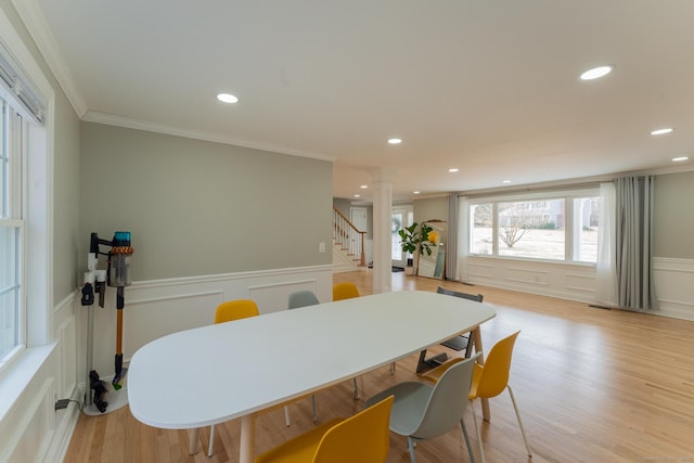 dining space featuring a decorative wall, recessed lighting, light wood-style floors, and ornamental molding