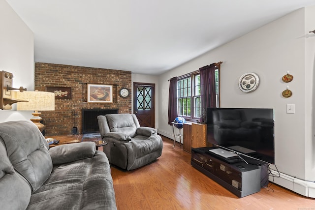 4 Wildwood Ln, Weston, CT 06883 - living room featuring baseboard heating, wood finished floors, a baseboard radiator, and a brick fireplace