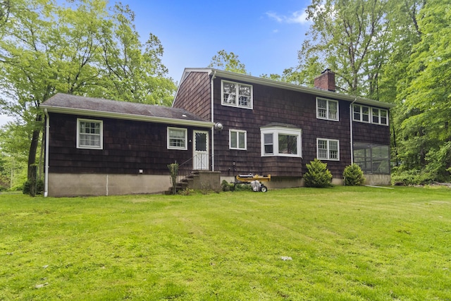 4 Wildwood Ln, Weston, CT 06883 - rear view of property featuring entry steps, a chimney, a yard, and a sunroom