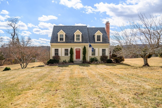 cape cod house with a shingled roof, a front lawn, and a chimney